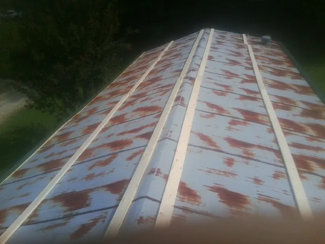Rusted metal roof panels with new wood purlins before replacement — Storm Damage Roof Repair in Fellsmere by Roofing Brothers